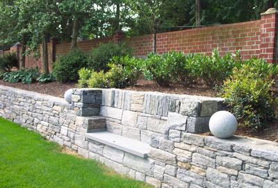 A stone bench is created within a restored retaining wall.